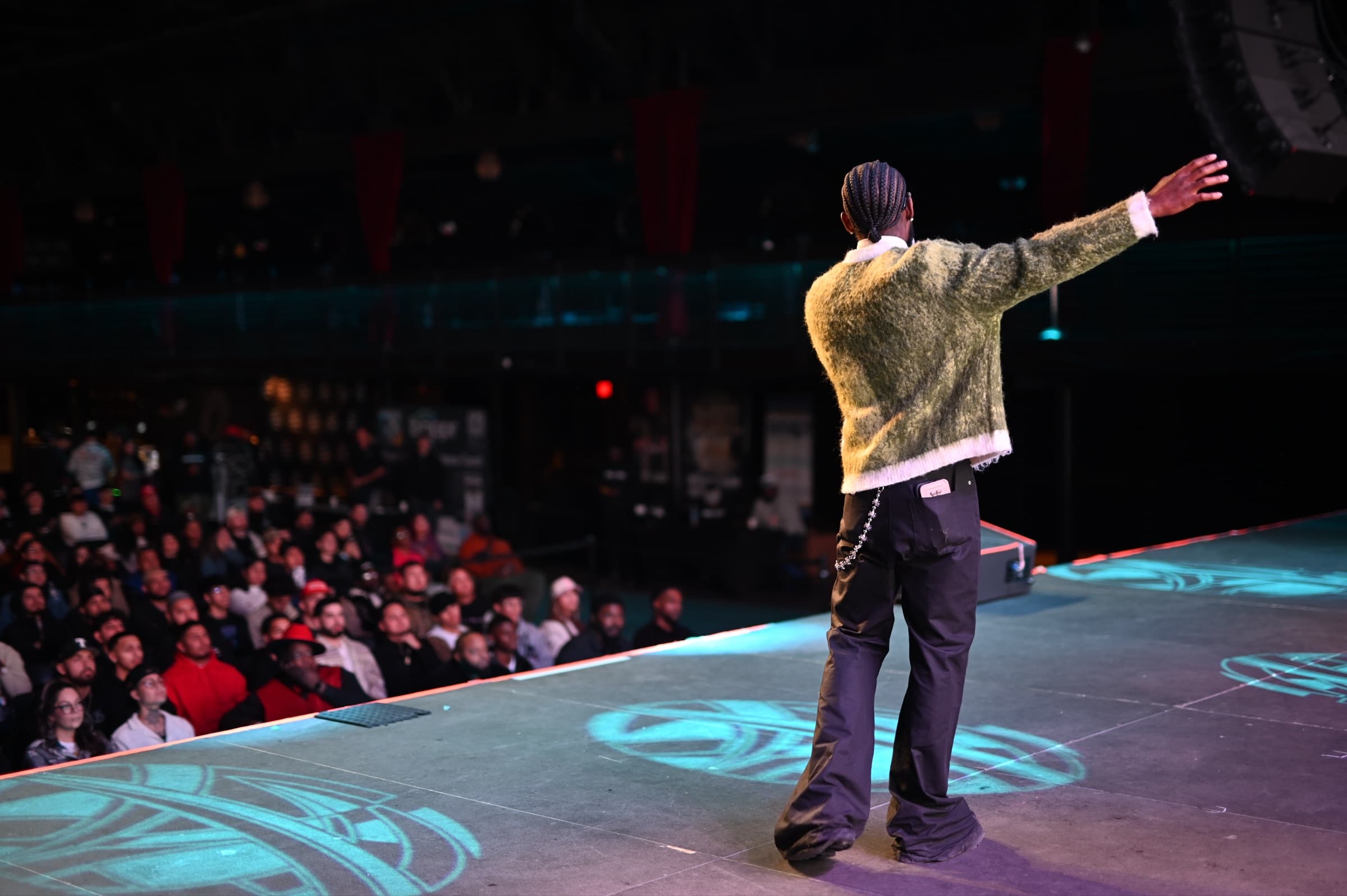 Sly Huncho speaking to an audience from the stage