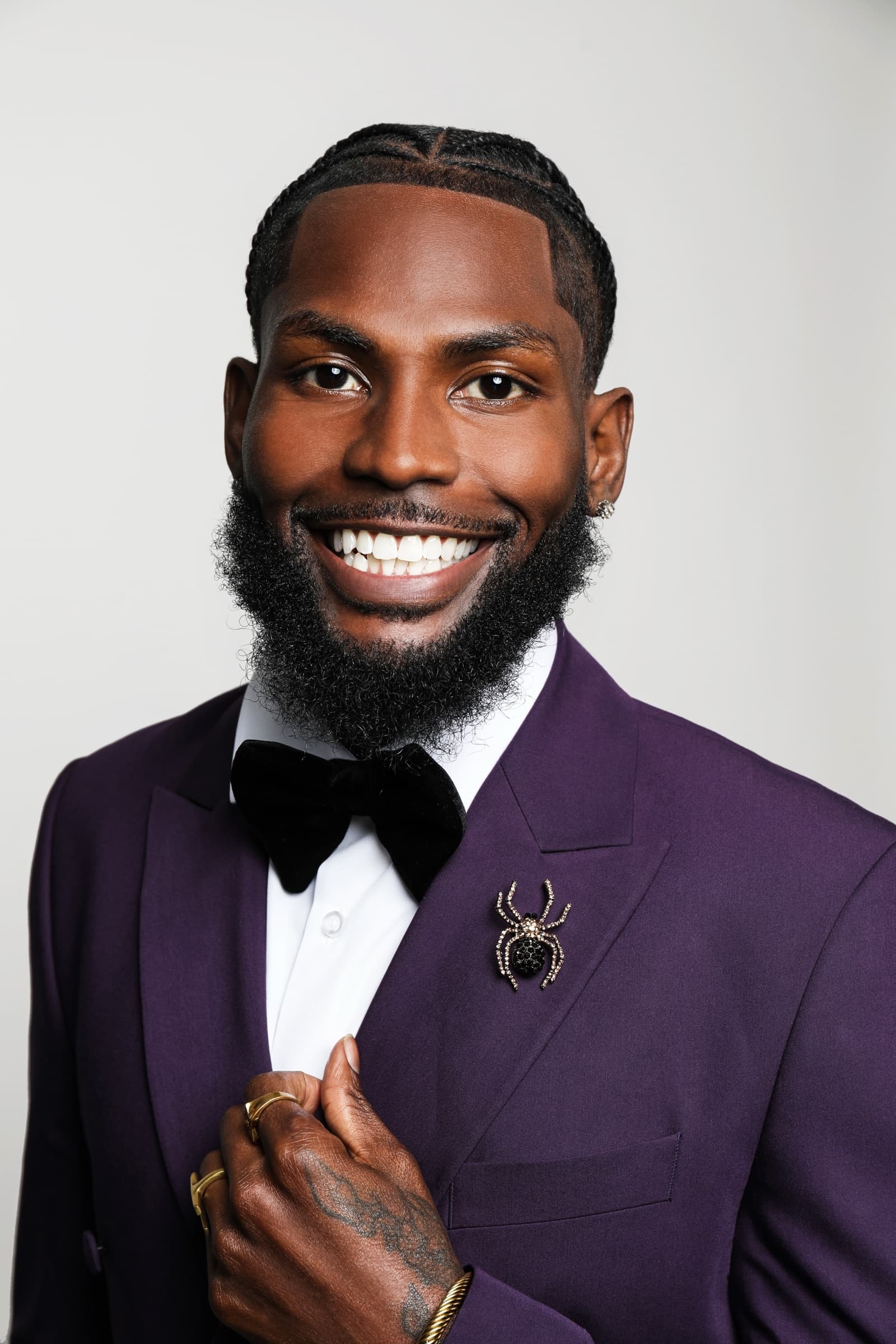 Close portrait of Sly Huncho in a purple tuxedo